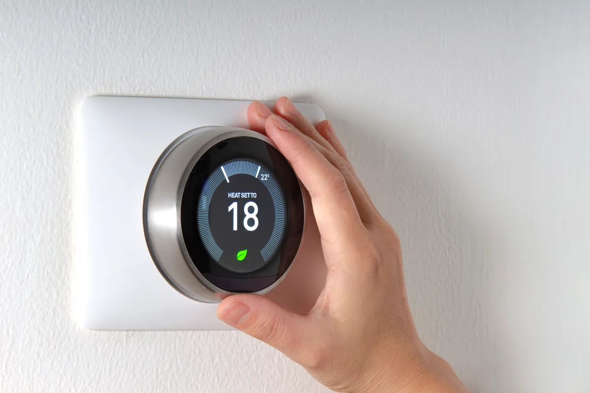 Hand adjusting a smart thermostat